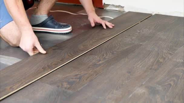 Laminátové podlahy - pracovník instalace nové podlahy v místnosti