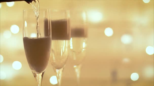 nalévat šampaňské z láhve do flétny přes blikající světlé pozadí