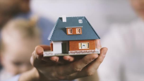 新しいホーム コンセプト 若い家族の手で夢の家スケール モデルと — ストック動画