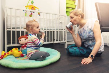 Anne ve kızı teneke telefon ile oynuyorlar. veli ve çocuk iletişimi kavramı