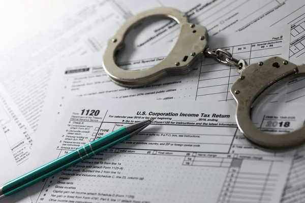 tax evasion and avoidance concept. annual income declaration form and handcuffs