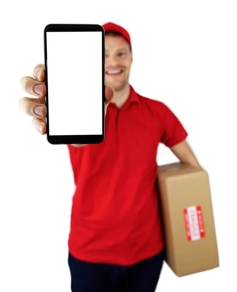 Usmívající se doručovatel ukazující smartphone s prázdnou obrazovkou — Stock fotografie