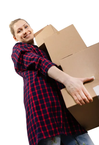 Moving to new house - smiling young woman with stack of cardboar — стоковое фото