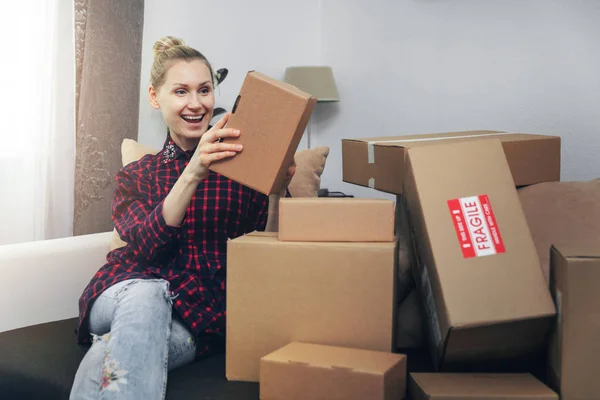 Donna eccitata che apre scatole dopo la consegna a casa — Foto Stock