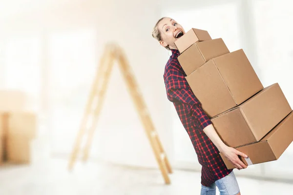 Frau zieht in neue Wohnung und hält Stapel Pappkartons — Stockfoto