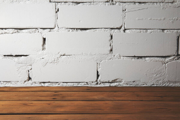 old plank wooden floor with white brick wall