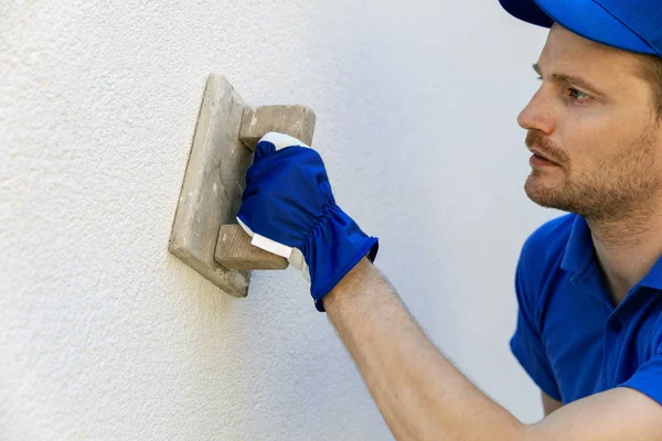 Uomo applicando intonaco facciata decorativa con spatola su uscita casa — Foto Stock