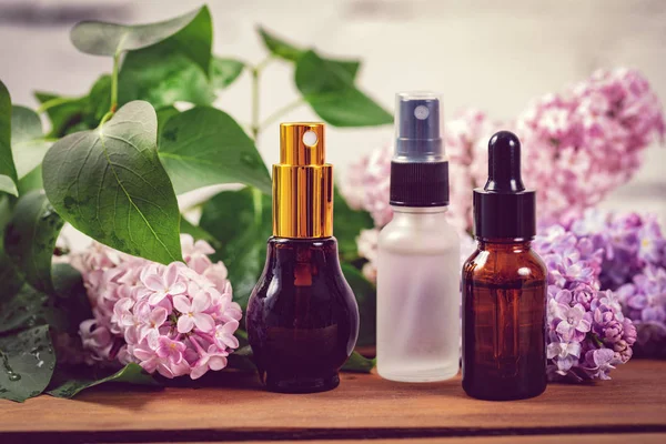 Vonné spreje a lahvičky éterického oleje s šeříkovými květy — Stock fotografie