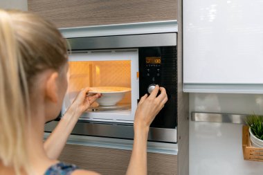 kadın evde mikrodalga fırında gıda ısınmak