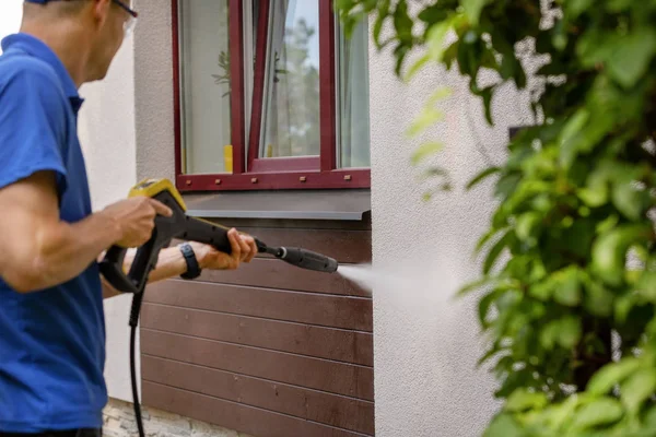 Ház homlokzata takarítás. férfi mosó fal nagy nagynyomású Stock Kép