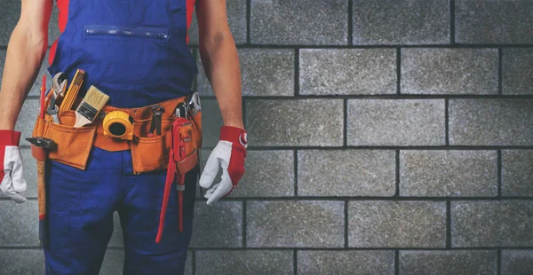 Trabajador de la construcción con correa de herramientas en la pared del bloque copia de fondo —  Fotos de Stock