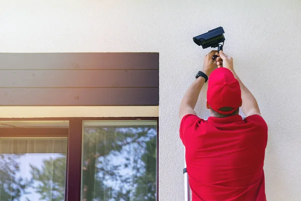 Techniker installiert Außen-Überwachungskamera am Haus — Stockfoto