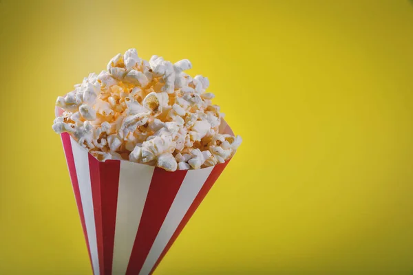 Striped pop corn bag on yellow background with copy space — Stock Photo, Image