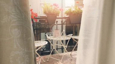 rüzgarda esen çiçek kutuları ve perdeler ile küçük romantik balkon