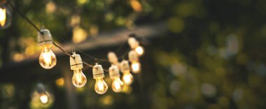 kopya alanı ile yeşil bokeh arka bahçesinde asılı açık parti dize ışıkları