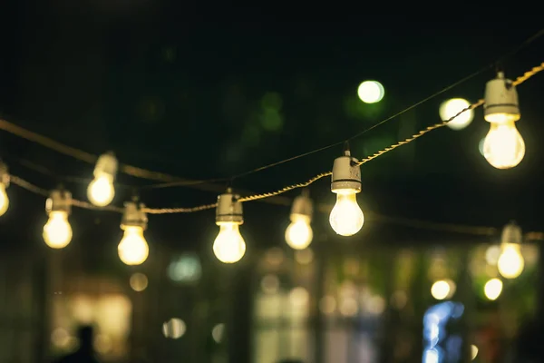 Luces de cadena de fiesta al aire libre que brillan por la noche —  Fotos de Stock