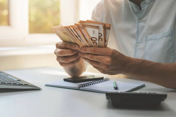 Geschäftserfolg - Geschäftsmann, der im Büro Bargeld zählt — Stockfoto