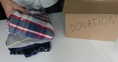 sadaka - evde adam bağış karton kutuya giysi koymak