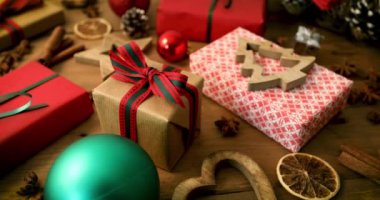 ahşap tahta arka plan üzerinde sarılmış noel hediyeleri ve süslemeleri. dolly atış