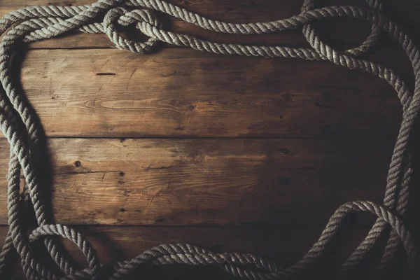 Rope frame on old brown wooden plank background — Stock Photo, Image