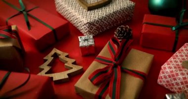 sarılmış noel hediyeleri ve kırmızı kağıt arka plan üzerinde ahşap köknar ağacı dekorasyon. dolly atış