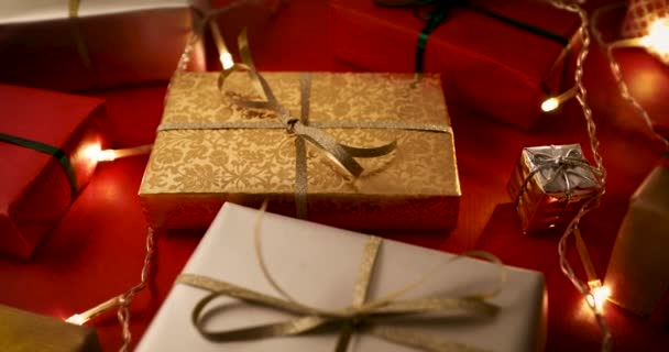 圣诞礼物和红色背景上的灯 多莉拍摄 — 图库视频影像