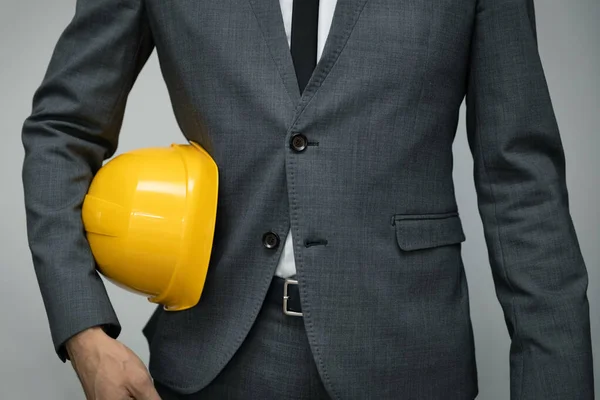 Segurança no trabalho ou conceito de negócio de construção - empresário segurando coxa capacete amarelo — Fotografia de Stock