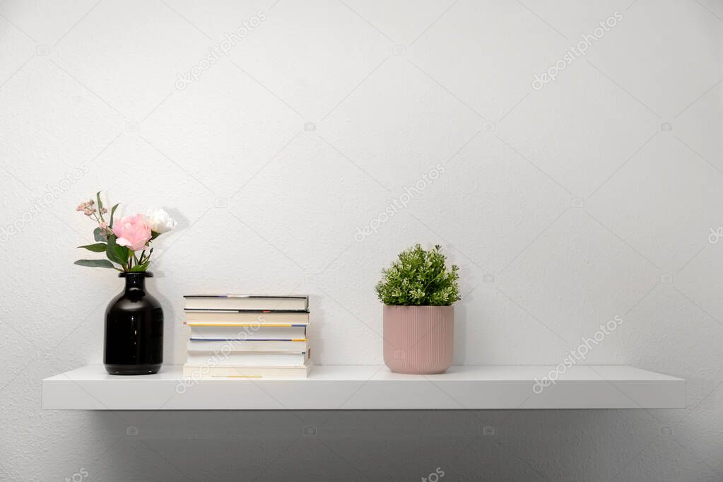 bookshef on white wall with decorations