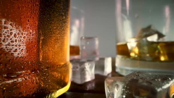 Whiskey Bottle Glasses Ice Cubes Closeup Dolly Shot — Stock Video