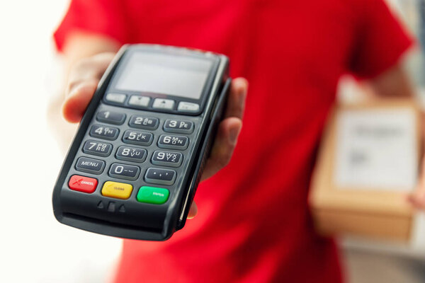 delivery man with parcel and pos terminal for payment