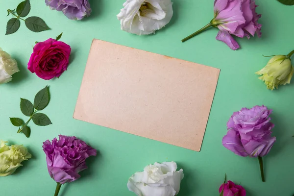 緑の背景に花枠のついた空白のグリーティングカード トップビュー — ストック写真