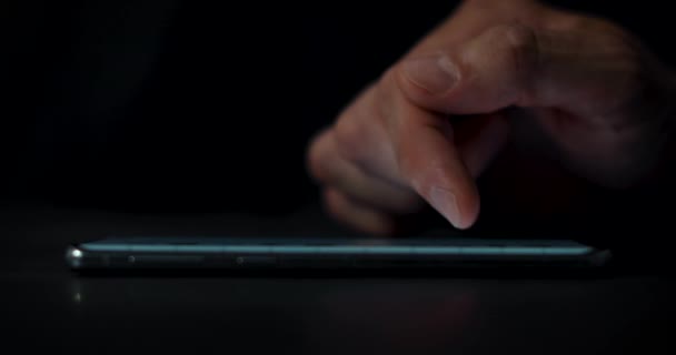 main défilement écran de téléphone dans le noir. gros plan