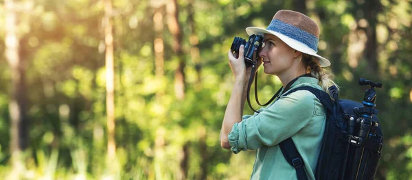 自然写真 森の中でアナログフィルムカメラで写真を撮る女性写真家 バナーコピースペース — ストック写真