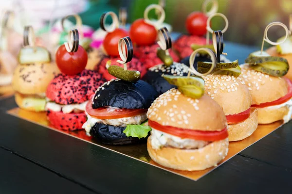 buffet with mini burgers, sliders. catering banquet table with appetizers. party food