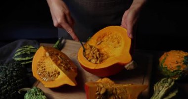 Kabağı pişirmeye hazırlayan kadın, kaşıkla tohumları ayır.