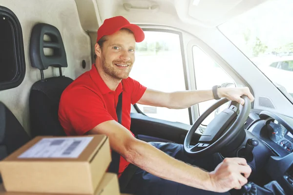 Χαμογελαστός Άνθρωπος Υπηρεσία Παράδοσης Κόκκινο Φορτηγό Ομοιόμορφη Οδήγηση Και Την — Φωτογραφία Αρχείου