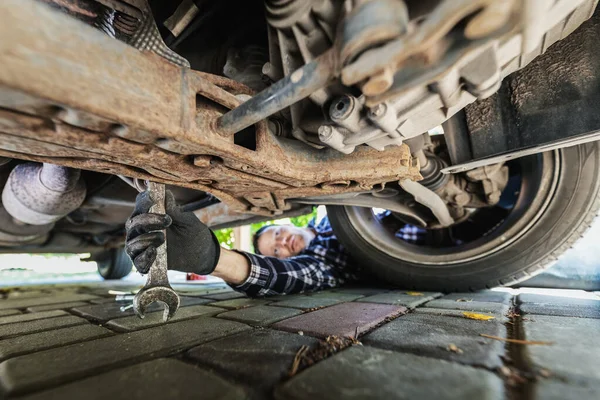 Homem Reparando Carro Sistema Suspensão Inspeção Mecânica Sob Veículo Garagem — Fotografia de Stock