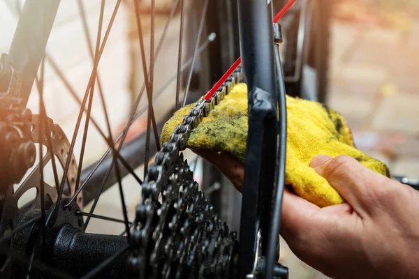 bicycle maintenance and repair - cleaning and oiling mountain bike chain and gear with oil spray