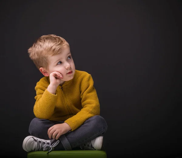 Petit Garçon Réfléchi Assis Sur Une Chaise Cherchant Copier Espace — Photo