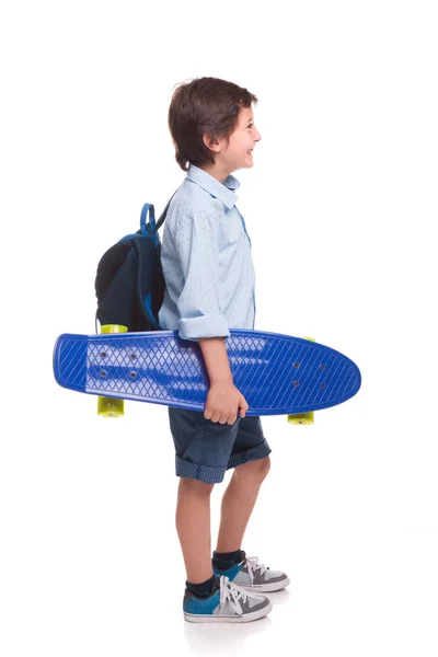 Усміхнений хлопчик тримає скейтборд на білому тлі — стокове фото