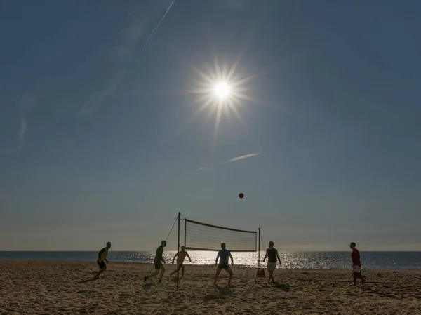 Silhouette of people playing foot volley Stock Photo
