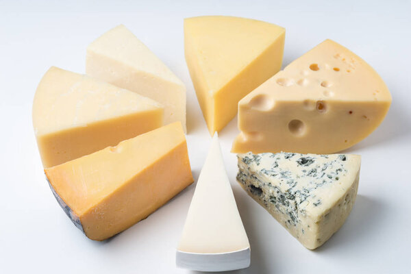 A large variety of cheeses triangles  on an white backgroud