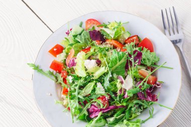 Taze salata yeşil ve mor marul, domates ve salatalık Beyaz ahşap zemin üzerine kapatın. Sağlıklı gıda.