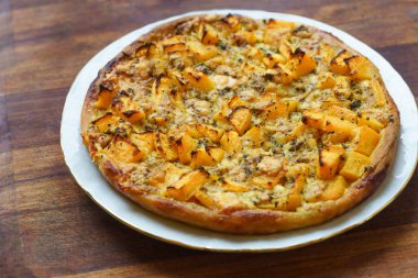 sebze havuç kabak ve otlar beyaz tabak ve rustik masa mevsim sonbahar pizza.