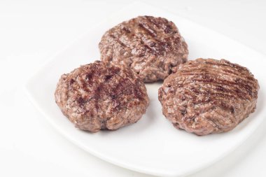 Gıda: üç taze çiğ ev yapımı pirzola beyaz arka plan üzerinde izole bir plaka üzerinde