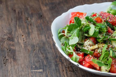 Oraganic sebze salatası marul, salatalık, domates ve kopya alanı rustik zemin üzerine keten tohumu