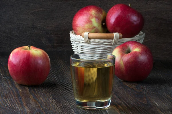 一杯苹果汁和成熟的苹果在一个质朴的厨房桌子上 — 图库照片