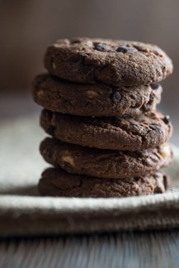 Ahşap masa arka plan üzerinde ev yapımı çikolatalı kurabiye. Yemek pişirme. Keten kumaş.