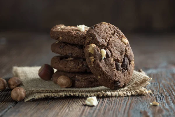 Homemade chocolate cookies on wooden table background. Food baking. Linen cloth.