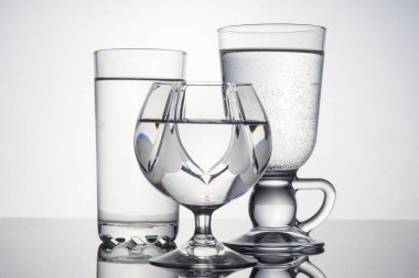 Grup gözlük siyah ayna yansıması ile beyaz arka plan üzerinde su dolu.